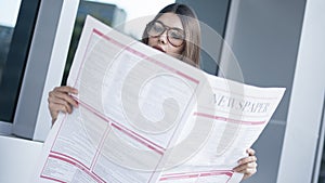Young woman reading newspaper in outdoors