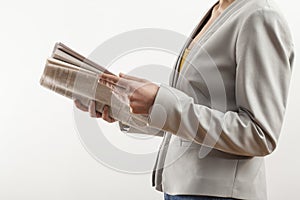 Young woman reading newspaper on white background