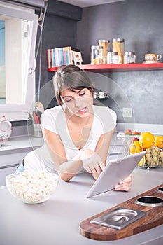 Young woman reading recipe tablet kitchen searching