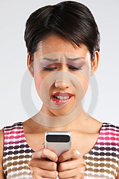 Young Woman Reading Text Message With Anxious Expression