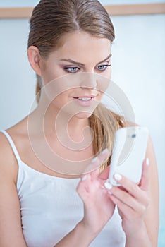 Young woman reading a text message on her mobile