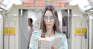 A young woman reads the book in railway wagon