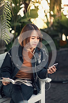 Young woman reads and listens to music