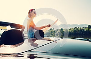 Young woman reads a roads map during auto travel