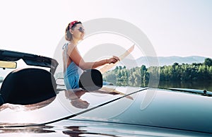 Young woman reads a roads map during auto travel