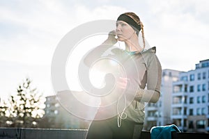 Young woman ready for outdoor workout listening to music through