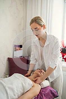 young woman receive manual relax massage on neck lying on table in spa salon