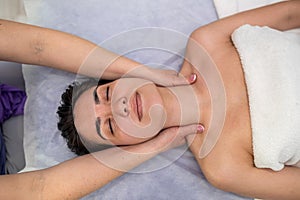 young woman receive manual relax massage on neck lying on table in spa salon