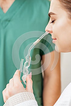 Young woman receives nasal inhalation