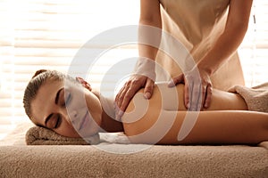 Young woman receiving back massage in spa salon