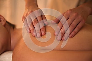 Young woman receiving back massage in spa salon, closeup