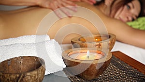 Young woman receiving a back massage in the spa salon. closeup hands of the masseur