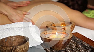 Young woman receiving a back massage in the spa salon. closeup hands of the masseur