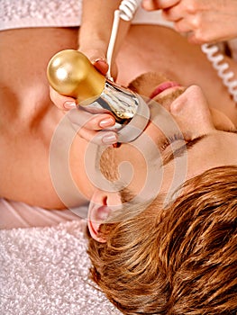 Young woman receiving electric facial massage photo