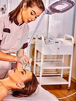 Young woman receiving electric facial massage. photo