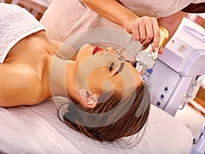 Young woman receiving electric facial massage photo