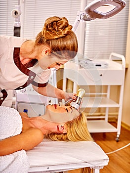 Young woman receiving electric facial massage photo