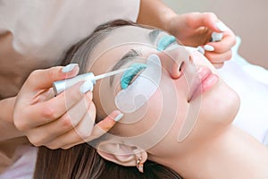 Young woman receiving eyelash lamination procedure in a beauty salon