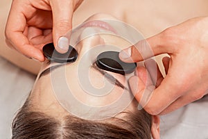 Young woman receiving facial massage.