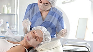 Young woman receiving facial radiofrequency procedure stimulating collagen production resulting in tightened and firmed