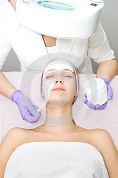 Young woman receiving facial treatment