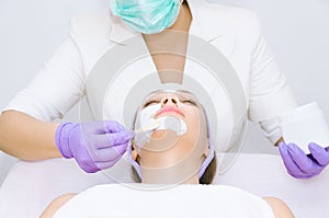 Young woman receiving facial treatment