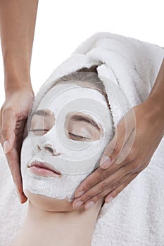 Young woman receiving facial treatment at spa