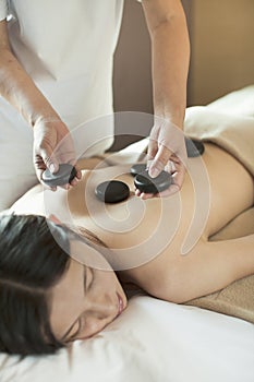 Young Woman Receiving Hot Stone Massage