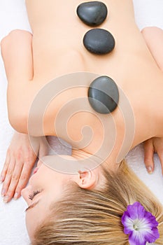 Young woman receiving hot stone treatment