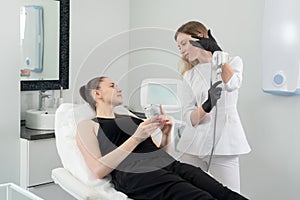 Young woman receiving laser treatment in cosmetology clinic