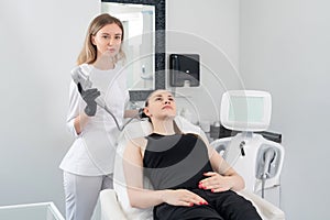 Young woman receiving laser treatment in cosmetology clinic