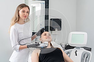 Young woman receiving laser treatment in cosmetology clinic