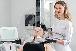 Young woman receiving laser treatment in cosmetology clinic