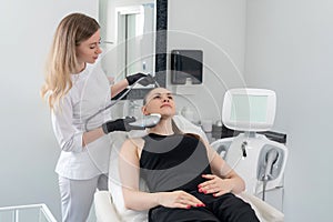 Young woman receiving laser treatment in cosmetology clinic