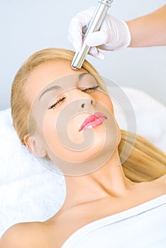 Young woman receiving microdermabrasion treatment