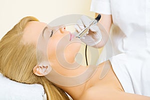 Young woman receiving microdermabrasion treatment