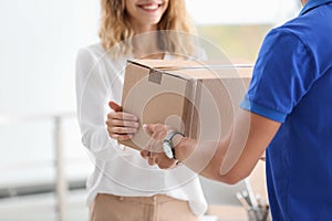 Young woman receiving parcel from courier photo