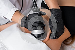 A young woman receiving ultrasound cavitation treatment for body contouring of belly
