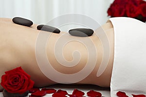 Young Woman Receiving Warm Stone Massage Red Roses