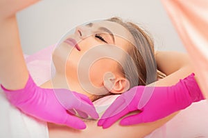 Young woman receiving waxing armpit