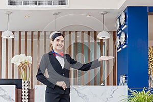 Young woman receptionist standing and smiling at the front desk of the hotel reception, Portrait of Female receptionist working in