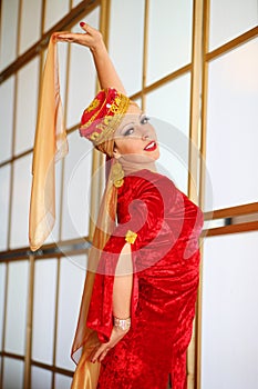 Young woman in red Andalusian costume poses with