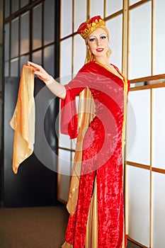 Young woman in red Andalusian costume stands in