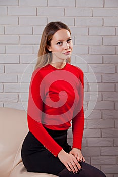 Young woman in red blouse next to brick wall Stylish fashion mod