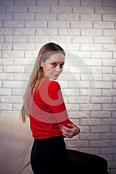 Young woman in red blouse next to brick wall Stylish fashion mod
