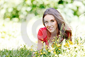 Young woman in red dress lying on grass