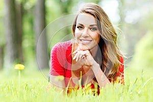 Young woman in red dress lying on grass