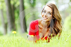 Young woman in red dress lying on grass