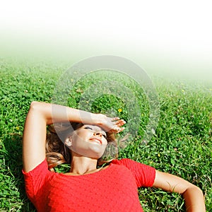 Young woman in red dress lying on grass