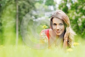 Young woman in red dress lying on grass